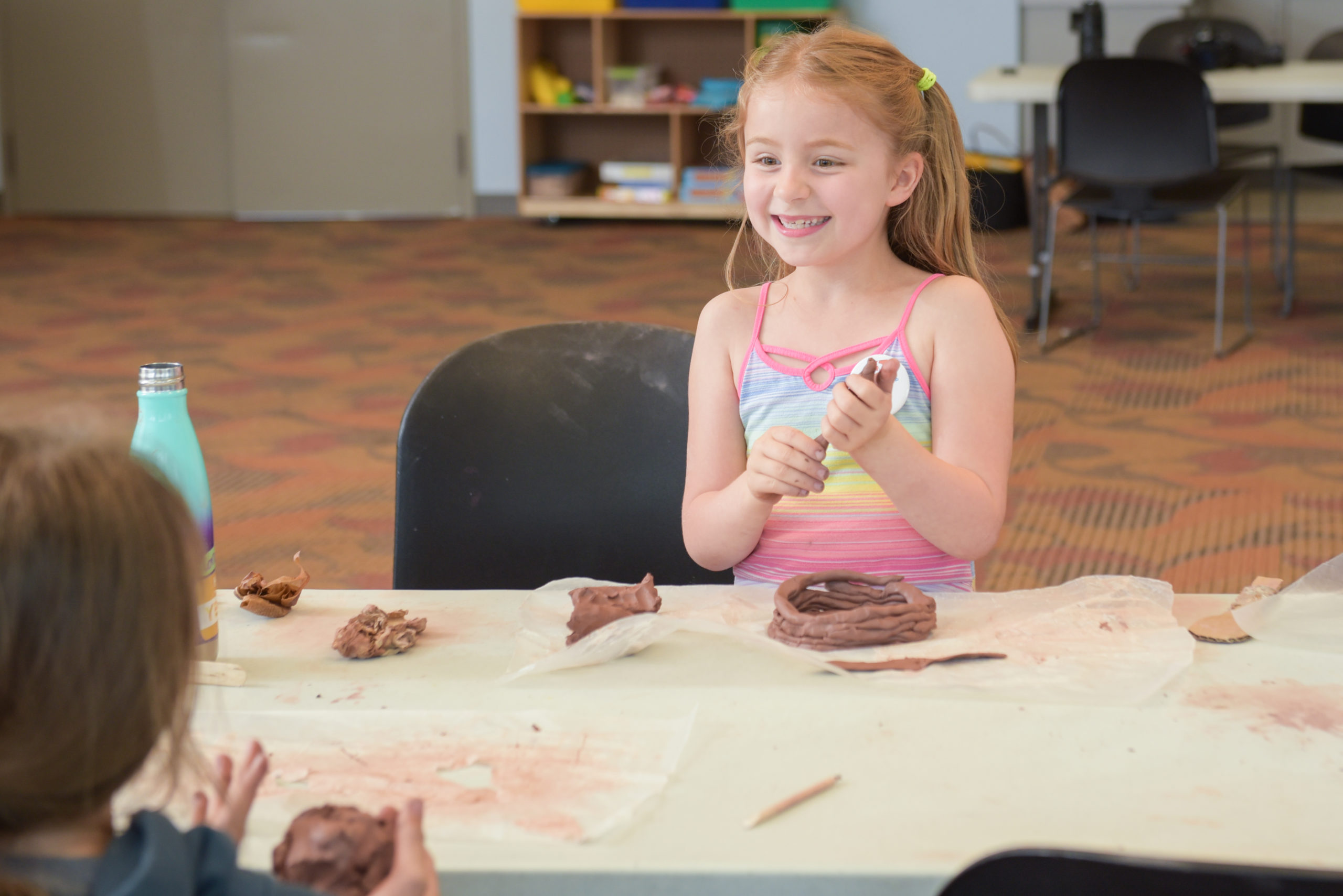young girl at table playing with clay