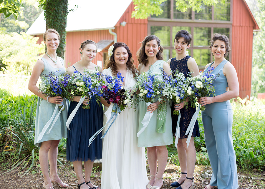 Bride and bridesmaids posing with blue bouquets