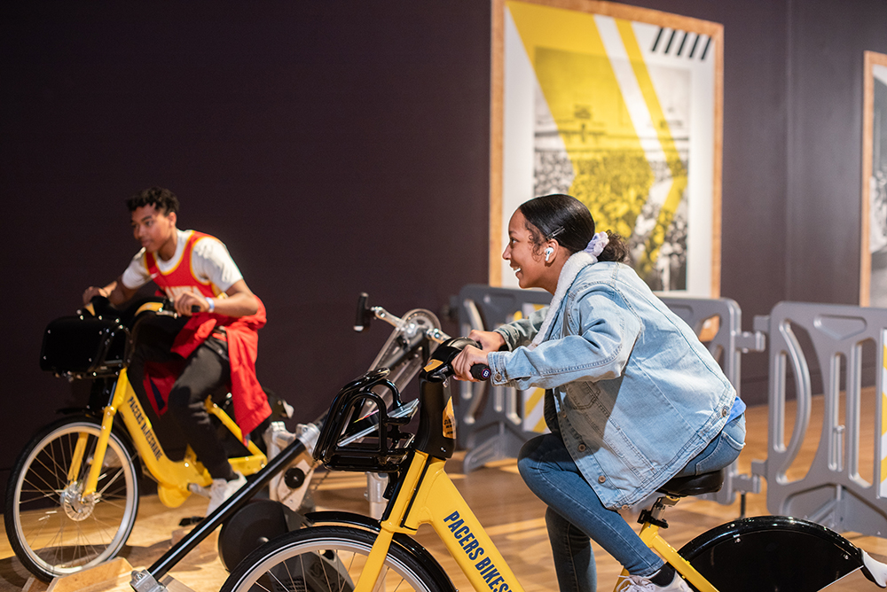 Children racing on stationary bikes in Major Taylor exhibit