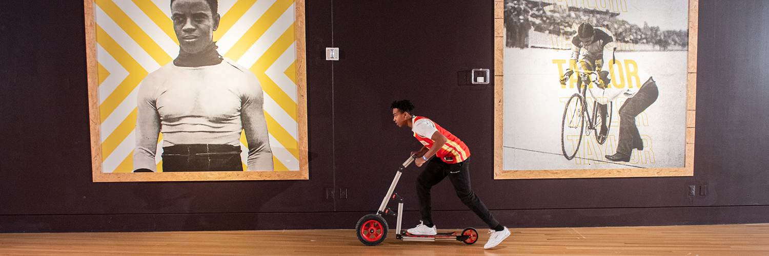 Child pushing scooter in Major Taylor exhibit