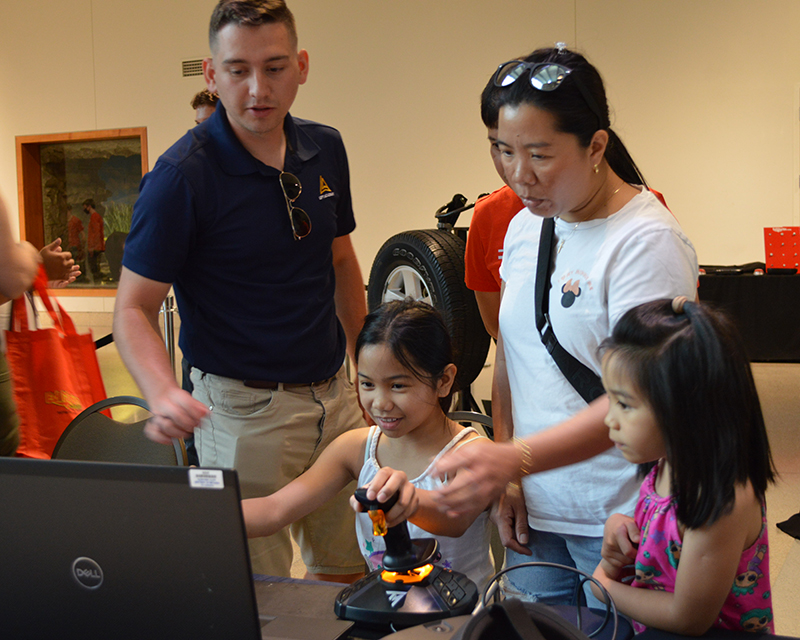 family engaging with activity at tinkerfest