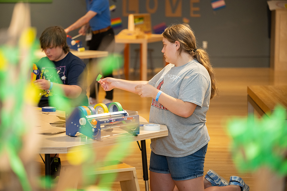 Woman playing in Cardboard Engineering: Build a City exhibit