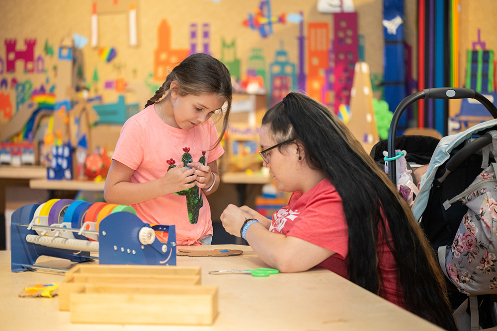 Two children playing in Cardboard Engineering: Build a City exhibit