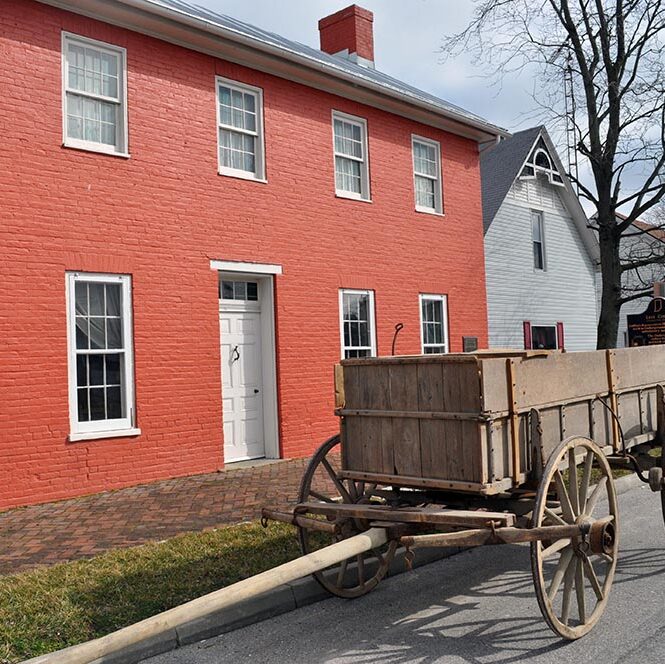 wooden wagon in front of red brick building