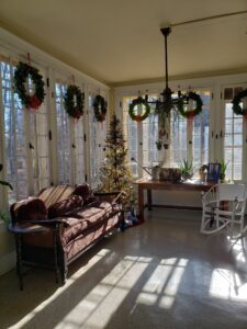 Sun room decorated for the holidays with wreaths on windows at Gene Stratton-Porter State Historic Site