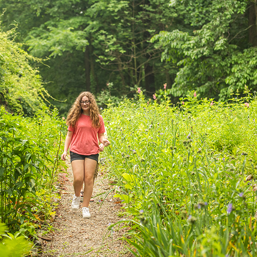 Girl walking through gardens at Gene Stratton-Porter State Historic Site