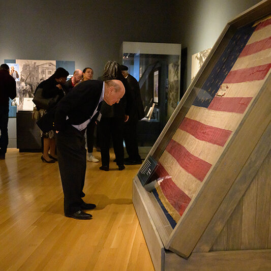 Man bending down looking at flag
